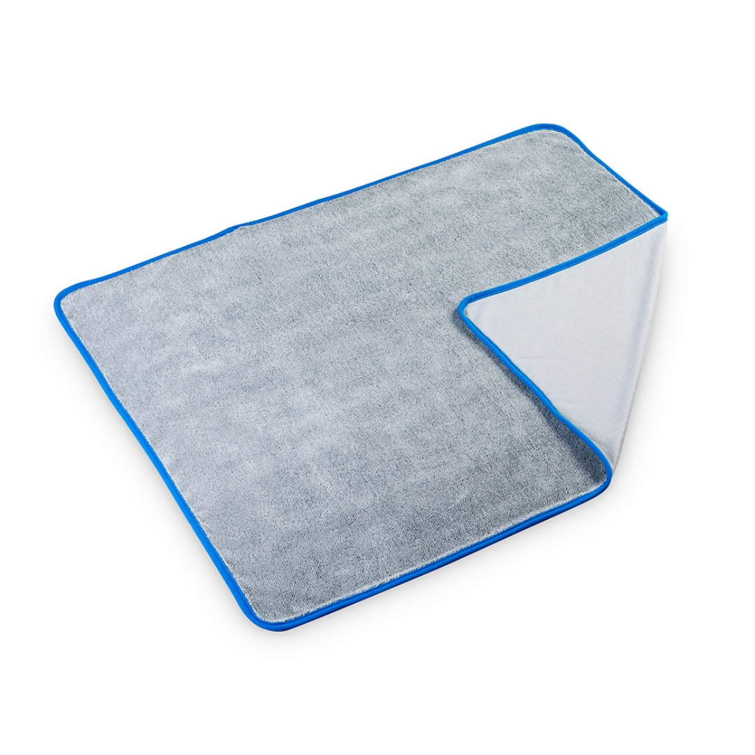FX Protect Twisted Loop Drying Towel 74x90cm ručnik napravljen je od mikrofibre sive boje i opšivenih rubova plave boje.